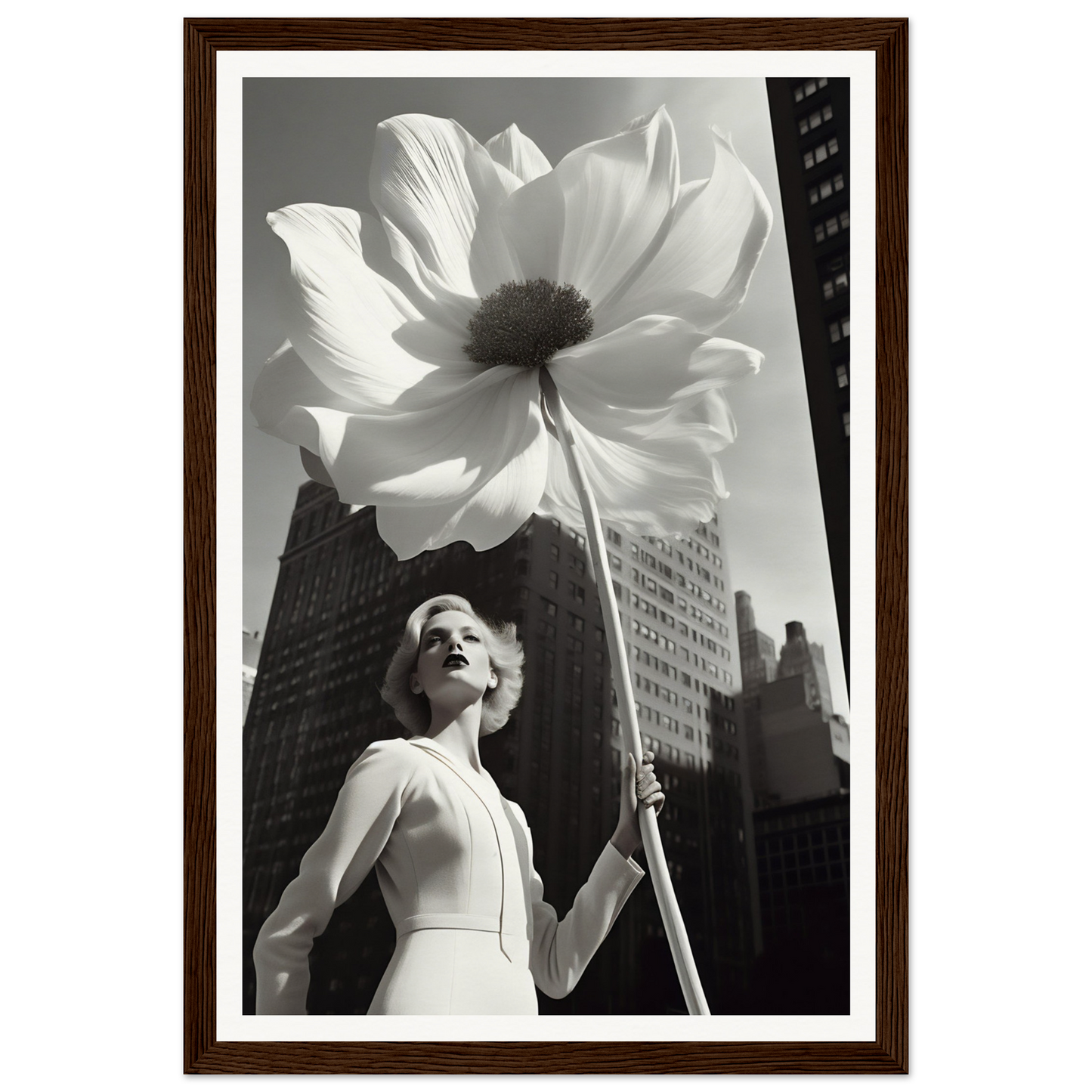 A woman holding a large white flower in front of a tall building