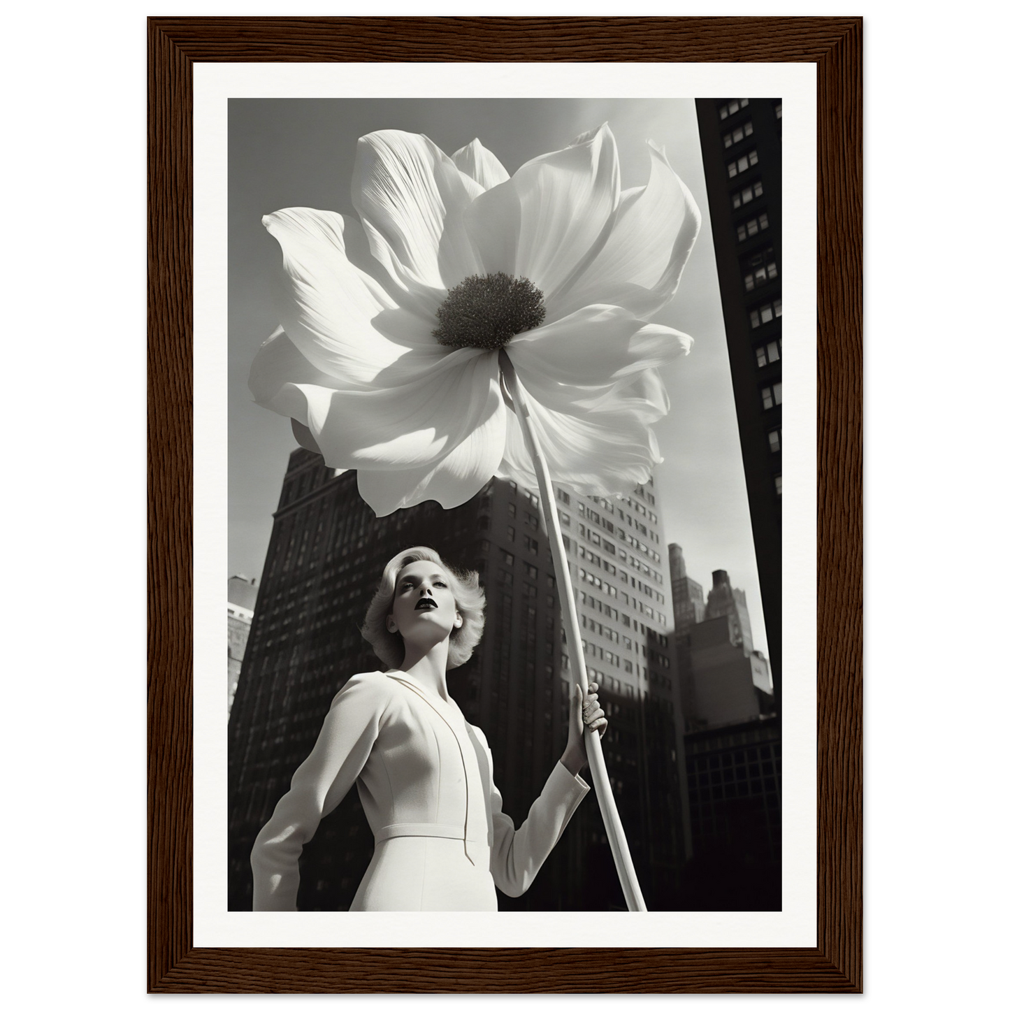 A woman holding a large white flower in front of a tall building